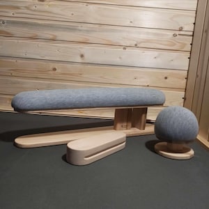 May include: A wooden tailor's pressing set, including a long, padded board, a rounded pressing ham, and a small pressing block. The set features light grey fabric and natural wood tones. Designed for garment construction and finishing.