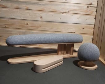 May include: A wooden tailor's pressing set featuring a long, padded board, a rounded pressing ham, and a small pressing block. The set includes a light gray fabric and natural wood tones. The items are designed for garment construction and finishing.
