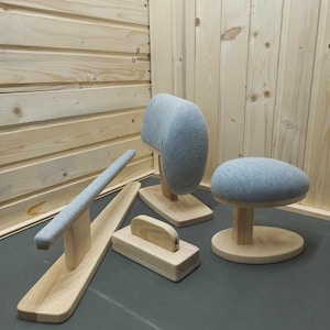 May include: Four wooden stands with gray fabric cushions. The stands are designed for use as a neck rest, a seat cushion, and a foot rest.