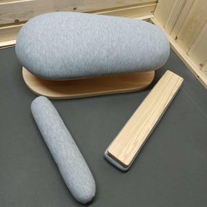 May include: A set of three grey fabric covered ironing forms with wooden bases. The forms are shaped like a large oval, a smaller oval, and a long rectangle.