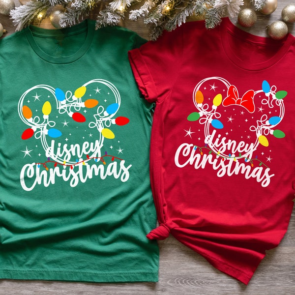 Könnte beinhalten: Ein grünes T-Shirt und ein rotes T-Shirt, jeweils mit einer weißen Umrisszeichnung eines Mauskopfes, verziert mit bunten Weihnachtslichterketten und Sternen. Unter der Silhouette steht der Text "disney Christmas" in weißer Schrift.