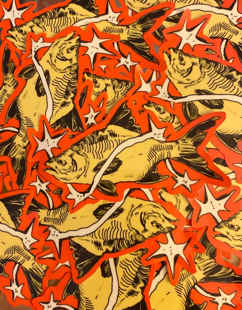 May include: A collection of die-cut stickers featuring a yellow fish illustration with black line details, surrounded by white star shapes and a vibrant orange border. The fish is depicted in a swimming position with visible scales and fins.