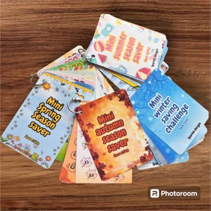May include: A set of colourful cards with a mini saving challenge theme. Each card features a different season, including spring, summer, autumn, and winter. The cards have a fun and playful design with illustrations of flowers, butterflies, leaves, and snowflakes. The text on the cards reads "Mini Spring Season Saver", "Mini Summer Season Saver", "Mini Autumn Season Saver", "Mini Winter Saving Challenge", and "Save £540".