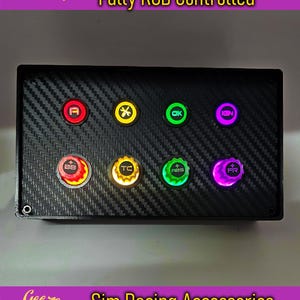 Pode incluir: Uma caixa de botões preta com textura de fibra de carbono, com oito botões iluminados e quatro codificadores rotativos. Os botões são rotulados e iluminados com várias cores. O texto na imagem diz "8 Push Buttons, 4 Rotary Encoders, Fully RGB Controlled."