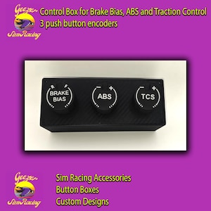 Può includere: Una scatola di controllo rettangolare nera per sim racing con tre encoder a pulsante circolari. Ogni manopola presenta scritte bianche: BRAKE BIAS con indicatori R e F, ABS con segni più e meno, e TCS con segni più e meno incisi sopra.