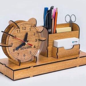 May include: Wooden desk organiser with a clock face, pen holders, and a compartment for business cards. The clock face reads "BD Craft".
