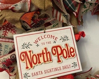 Welcome to the North Pole!  This lovely Seasonal Christmas Wreath is 24" in diameter once the ribbons are attached.  It is a 18" wire form.