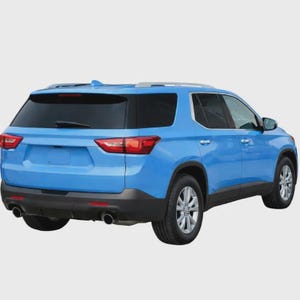 May include: A bright blue SUV viewed from the rear three-quarter angle, featuring dark tinted windows, a rear windscreen wiper, dual exhaust pipes, silver roof rails, and silver multi-spoke wheels with black trim along the lower body panels.