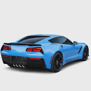 May include: A bright blue sports car viewed from the rear three-quarter angle. The vehicle features a black rear diffuser, four circular exhaust pipes, angular red taillights, a black rear spoiler, and dark multi-spoke alloy wheels.