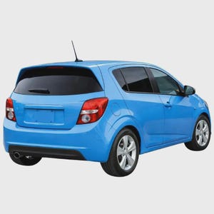 May include: A bright blue hatchback car viewed from the rear three-quarter angle. The vehicle features a rear windscreen wiper, a roof-mounted aerial, silver alloy wheels, and red and clear taillights. The body has a smooth, rounded design.