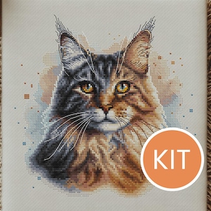 Può includere: Kit per punto croce con un ritratto dettagliato di un gatto. Il pelo del gatto è un mix di marrone, nero e marrone chiaro, con occhi gialli sorprendenti. La parola "KIT" è in un cerchio in basso a destra. Lo sfondo ha un effetto acquerello.
