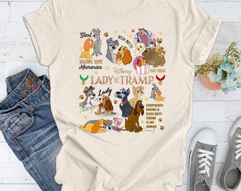 May include: A beige t-shirt with a graphic print of Lady and the Tramp characters. The graphic includes the text "Start", "Bella Notte", "Building Some Memories", "Disney", "Lady and the Tramp", "Lady", "Tramp", "Est. 1955", and "Everybody Knows a Dogs Best Friend Is His Human".