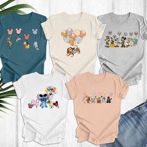 May include: Four different t-shirts with various Disney character designs. The shirts are all short-sleeved and have a crew neck. The designs include Stitch holding balloons, Mickey Mouse holding balloons, and a group of Disney characters holding balloons.