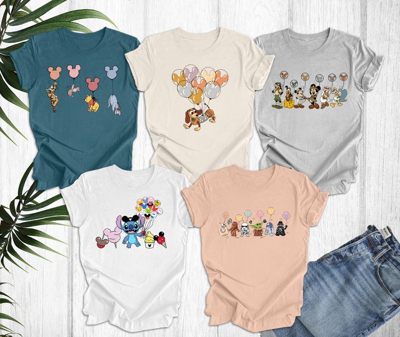 May include: Four different t-shirts with various Disney character designs. The shirts are all short-sleeved and have a crew neck. The designs include Stitch holding balloons, Mickey Mouse holding balloons, and a group of Disney characters holding balloons.
