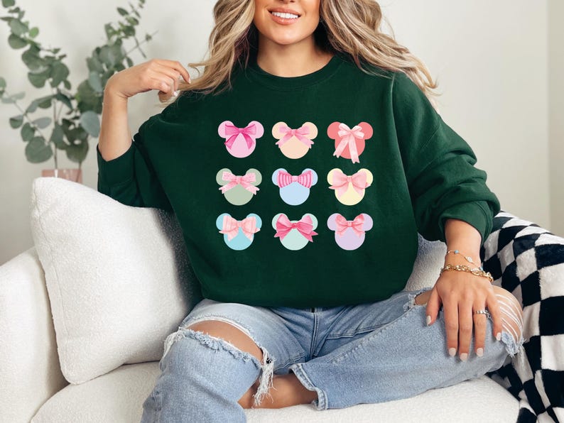 Puede incluir: Una sudadera verde oscuro con un patr&oacute;n de nueve dise&ntilde;os coloridos en forma de lazo. Cada lazo es de un color pastel diferente, con acentos rosas, azules y amarillos. La sudadera es de estilo casual, adecuada para el uso diario.