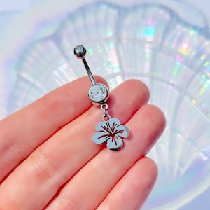 May include: Silver belly button ring with a clear crystal and a dangling silver hibiscus flower charm.