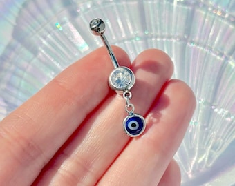 May include: Silver belly button ring with a clear crystal charm and a dangling blue evil eye charm.