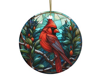 Può includere: Un ornamento natalizio in stile vetrata con un cardinale rosso appollaiato su un ramo con foglie verdi e bacche blu. Lo sfondo è un mosaico di blu, verde e bianco.