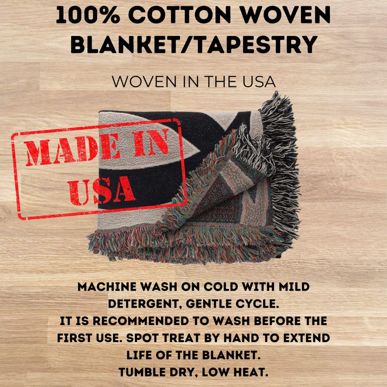 May include: A 100% cotton woven blanket or tapestry with fringed edges. The text reads 100% COTTON WOVEN BLANKET/TAPESTRY, WOVEN IN THE USA, MADE IN USA, and includes care instructions: MACHINE WASH ON COLD WITH MILD DETERGENT, GENTLE CYCLE.