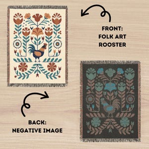 May include: A reversible woven throw blanket with a folk art rooster design. The front has a cream background with a rooster, flowers, and foliage in teal, brown, and orange. The back is a negative image on a dark grey background.