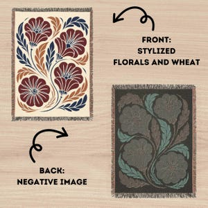 May include: A rectangular woven throw blanket featuring a stylized floral and wheat pattern. The front displays dark red flowers and navy blue leaves on a cream background. The back shows a negative image with dark gray and muted teal tones.