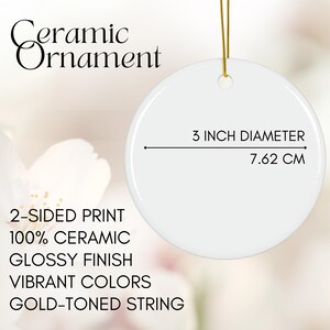 May include: A white ceramic ornament with a glossy finish and gold-toned string. The ornament is 3 inches in diameter (7.62 cm) and features a 2-sided print with vibrant colors.