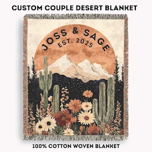 May include: A woven cotton blanket with a desert landscape design. The blanket features a sunset scene with mountains, cacti, and flowers. The text "JOSS & SAGE EST. 2025" is displayed. The blanket is fringed and the text "CUSTOM COUPLE DESERT BLANKET" and "100% COTTON WOVEN BLANKET" are also visible.