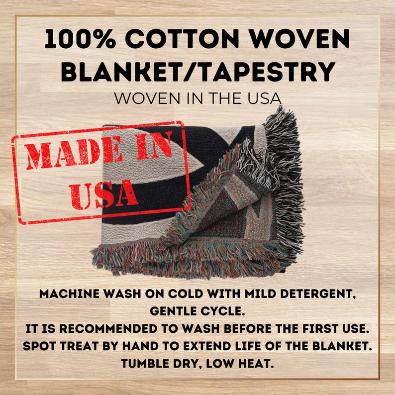 May include: A black and white woven tapestry blanket with fringe. The blanket is folded in half and has the words "Made in USA" printed on it. The text "100% Cotton Woven Blanket/Tapestry Woven in the USA" is printed above the blanket. The text below the blanket reads "Machine wash on cold with mild detergent, gentle cycle. It is recommended to wash before the first use. Spot treat by hand to extend life of the blanket. Tumble dry, low heat."