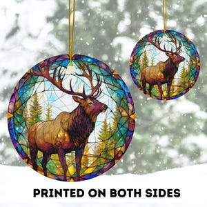 May include: A round ceramic ornament with a stained glass design featuring an elk standing in a forest. The ornament is printed on both sides.