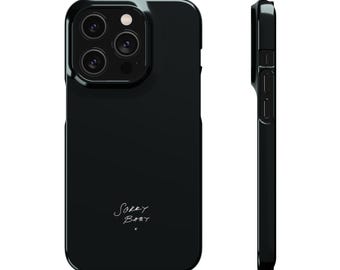 Peut inclure: Une coque de smartphone noire brillante avec une découpe pour triple objectif photo et le texte manuscrit blanc Sorry Baby imprimé en bas. Le design est présenté à la fois de face et de profil, montrant les découpes pour les boutons latéraux.