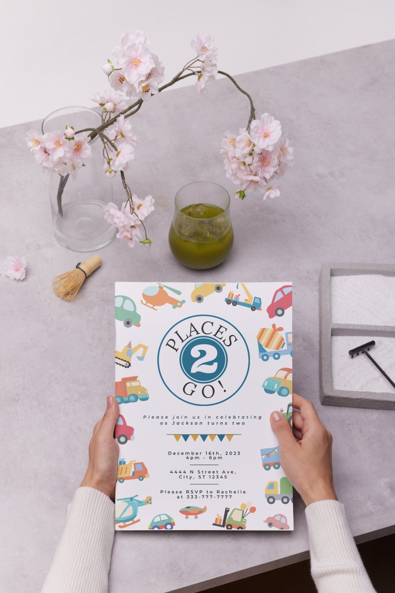 May include: A colorful invitation card with a blue circle and the text "Places 2 Go!" surrounded by illustrations of vehicles. The text "Please join us in celebrating as Jackson turns two" is below the circle. The date and time of the event are listed as "December 16th, 2023, 4pm - 6pm". The address is "4444 N Street Ave, City, ST 12345". The RSVP information is "Please RSVP to Rachelle at 333-777-7777".