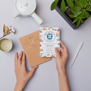 May include: A white envelope with a brown paper envelope inside. The brown envelope has a string tied around it with two brass grommets. The white envelope has a colorful invitation with the text "Places 2 Go!" and a design of toy vehicles.