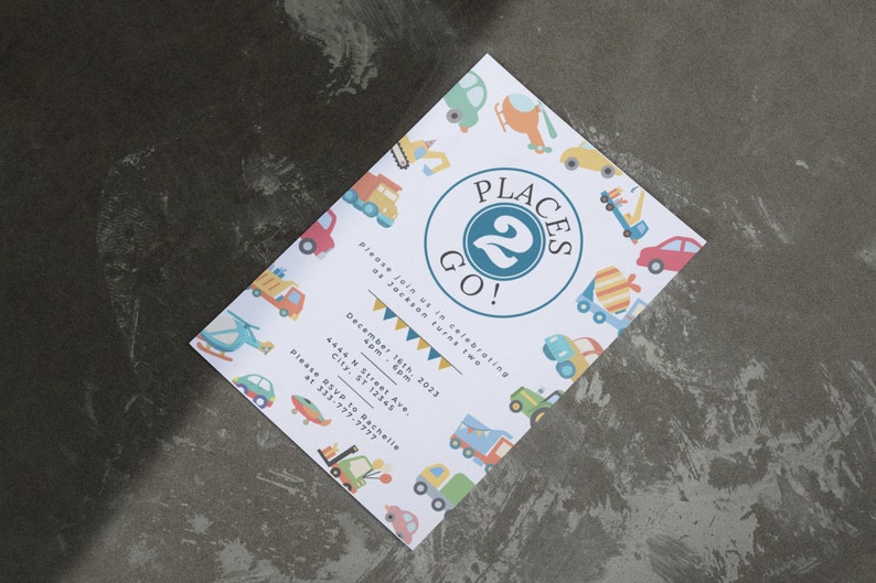May include: A white invitation with a blue circle that says "Places 2 Go!" with a number 2 inside the circle. The invitation is decorated with colorful cartoon vehicles and the text "Please join us in celebrating as Jackson turns two. December 16th, 2023 4pm - 6pm 4444 N Street Ave. City, ST 12345 Please RSVP to Rachelle at 333-777-7777"