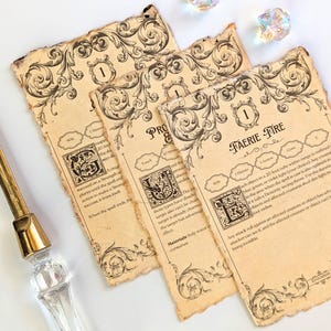 May include: Three aged-looking Faerie Fire spell cards with ornate black scrollwork and text, along with three iridescent dice. A clear and gold letter opener is in the image.