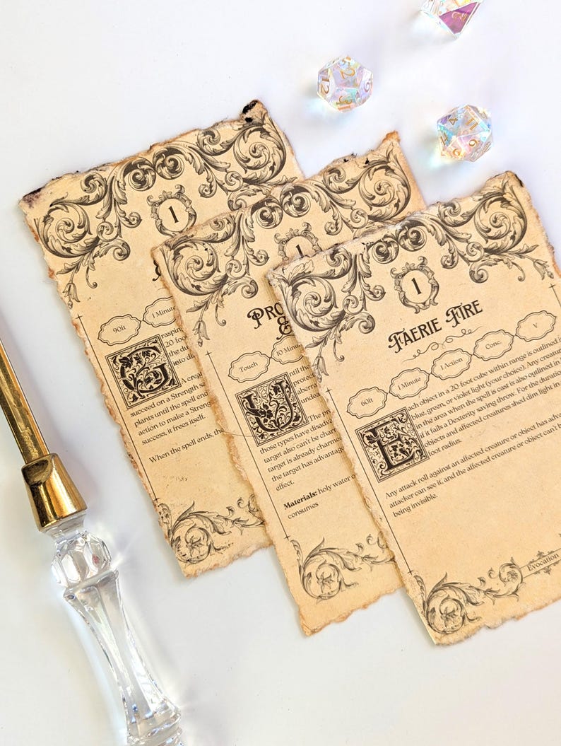 May include: Three aged-looking Faerie Fire spell cards with ornate black scrollwork and text, along with three iridescent dice. A clear and gold letter opener is in the image.