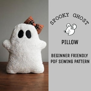 May include: A white plush ghost-shaped pillow with black felt eyes and a brown plaid bow on its head. The text reads: SPOOKY GHOST PILLOW BEGINNER FRIENDLY PDF SEWING PATTERN, accompanied by a small line-art illustration of a mouse face.