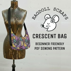Peut inclure: Un sac croissant en patchwork avec une bandoulière noire est présenté sur un mannequin vintage. Le sac présente un mélange de pièces de tissu violettes, jaunes et vertes. Le texte de l'image indique "Ragdoll Scraps" et "Crescent Bag".