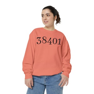 May include: A coral coloured sweatshirt with the number 38401 printed in black on the front.
