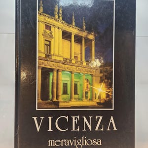 May include: A hardcover book with a dark cover featuring a nighttime image of a building with columns and statues. The title "VICENZA" is in large white letters, with "meravigliosa" below.