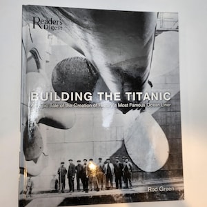 May include: A black and white book cover titled "BUILDING THE TITANIC" by Rod Green, published by Reader's Digest. The cover features a large image of the Titanic's propeller and a group of men. The subtitle reads "An Epic Tale of the Creation of History's Most Famous Ocean Liner."