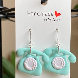 Peut inclure: Une paire de boucles d'oreilles en forme de téléphone vintage rotatif bleu turquoise avec des cadrans blancs. Les boucles d'oreilles sont faites à la main avec amour.