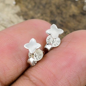 Può includere: Un paio di orecchini a stella in argento. Gli orecchini sono piccoli e delicati, e hanno un design semplice ed elegante.