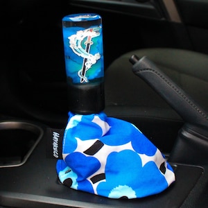 May include: A blue and white patterned gear shift knob with a clear cylinder containing a blue and white dragon and sword design. The text "HAYABUSA" is printed on the side of the knob.