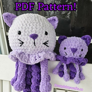 May include: Two plush cat-shaped toys, one large and one small, in shades of white and purple. The larger cat has a white head, purple ears, and a purple jellyfish-like body. The smaller cat is entirely purple. Text on the image reads "PDF Pattern!"