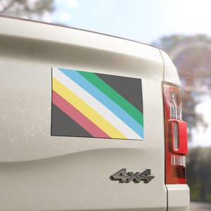 May include: A white truck with a 4x4 emblem on the back. A colorful rectangular sticker with a diagonal stripe design is on the back of the truck.