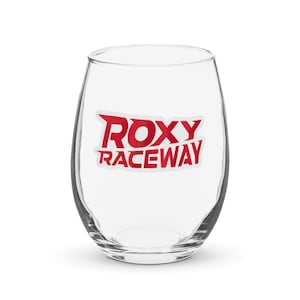 Puede incluir: Una copa de vino de vidrio transparente con una pegatina roja y blanca que dice "ROXY RACEWAY".