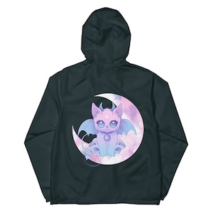 May include: A dark blue hooded jacket featuring a graphic of a purple and pink cat with wings sitting on a crescent moon with pink clouds.