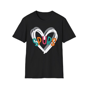 May include: Black t-shirt featuring a white, gray, and orange heart design with the word "SPURS" in colorful letters. The t-shirt is a classic crew neck style.