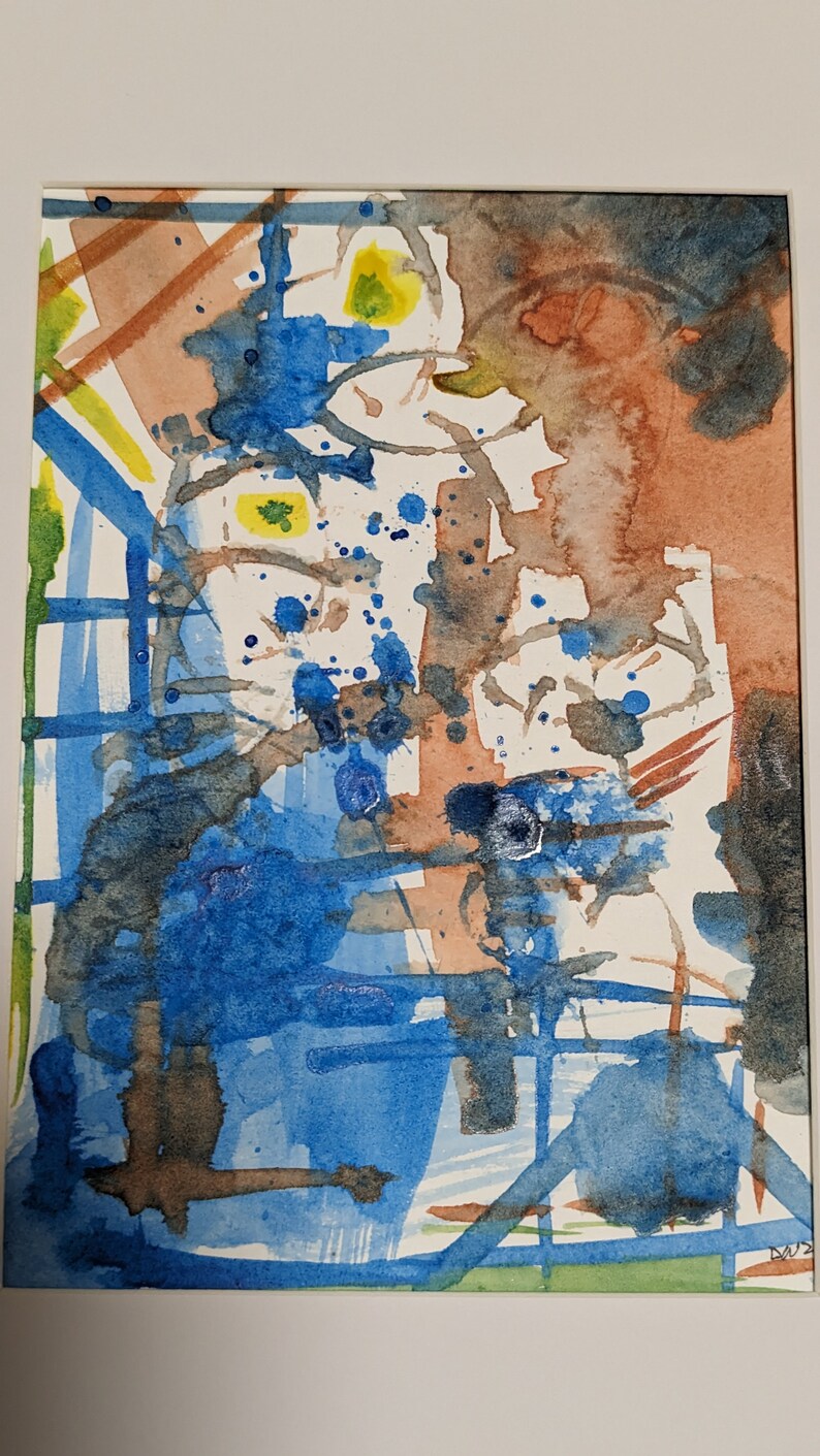 Puede incluir: Pintura abstracta de acuarela con salpicaduras de pintura azul, marr&oacute;n y amarilla sobre un fondo blanco.