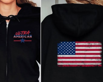 Puede incluir: Sudadera negra con cremallera y capucha, con un diseño de bandera americana desgastada en la espalda y el texto "Ultra American" en la parte delantera.